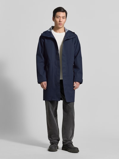 Männermodel trägt dunkelblaue Regenjacke mit Kapuze, Kordelzug, Seitliche Reißverschlusstaschen von GOFRANCK, Modell 'RAIN EATER', Gerader-Schnitt, Ganzkörperansicht von vorne.