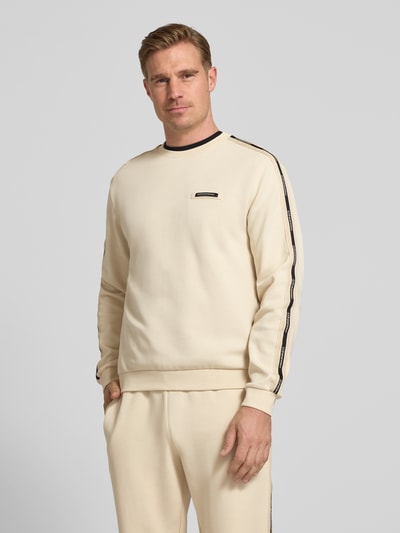 Männermodel trägt Sweatshirt mit Label-Details und Rundhalsausschnitt von EA7 Emporio Armani in Beige, Baumwoll-Mix, Regular-Fit, Ganzkörperansicht von vorne. Rückenlänge 63 cm, Ärmellänge 66 cm, Label-Details heben das Design hervor.