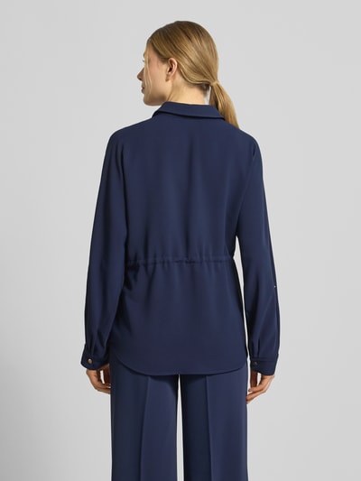 Männermodel trägt bluzka koszulowa Regular Fit Hemdbluse mit Brusttaschen Modell 'Februar' von More & More, tunel w talii, rękaw o dł. 3/4, kołnierzyk koszulowy, głęboki granat, gładka tkanina, długość tyłu w rozmiarze 36: 68 cm, długość rękawów w rozmiarze 36: 60 cm, Ganzkörperansicht Rückansicht