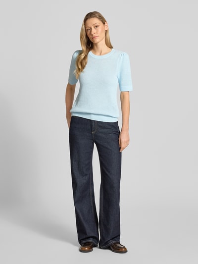 Kobiece model nosi damski t-shirt Slim Fit T-Shirt in Strick-Optik Modell 'Vidalo' od Vila z bawełny, imitacja dzianiny, okrągły dekolt, jasnoniebieski. Ganzkörperansicht von vorne.