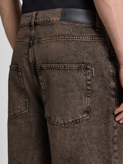 Männermodel trägt Jeansshorts mit Eingrifftaschen Modell 'Yuto Oak' von WOODBIRD, Reine Baumwolle, Relaxed-Fit, Detailaufnahme Rückansicht.
