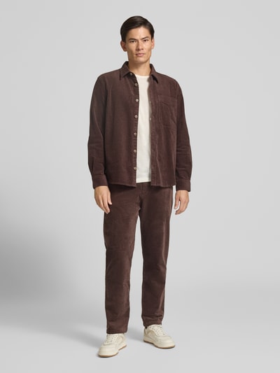 Männermodel trägt Comfort Fit Hemdjacke aus Baumwoll-Mix von s.Oliver RED LABEL in Braun mit sichtbarer Struktur, Ganzkörperansicht von vorne.