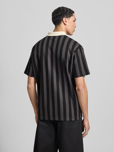Männermodel trägt Relaxed Fit Poloshirt mit Label-Stitching Modell 'CLASS' von PUMA aus Baumwoll-Mix, Rückenlänge 75 cm, Ganzkörperansicht Rückansicht.