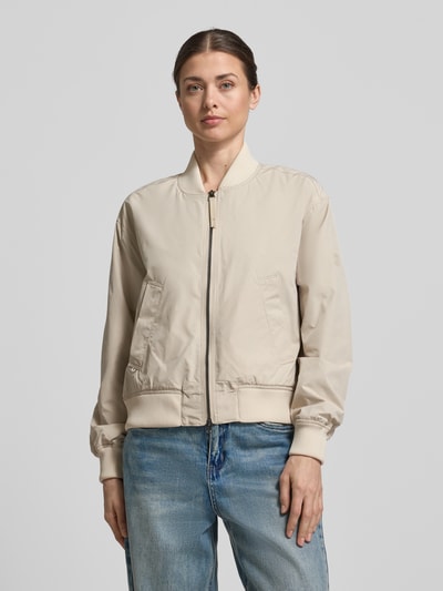 Modelka kobieca nosi Regular Fit Jacke mit Stehkragen von camel active w kolorze jasnobeżowym, dwukierunkowy zamek, kieszenie, elastyczne wykończenia, długość pleców w rozmiarze 36: 55 cm, szerokość ramion w rozmiarze 36: 43 cm, szerokość w biuście w rozmiarze 36: 53 cm, długość rękawa w rozmiarze 36: 59 cm, widok całej sylwetki od przodu