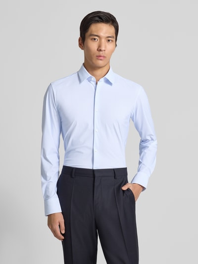 Männermodel trägt Slim Fit Businesshemd mit Allover-Muster Modell 'HANK' von BOSS, hellblau, Kentkragen, Langarm, Ganzkörperansicht von vorne.