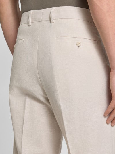 Männermodel trägt Anzughose aus Leinen-Mix mit Bügelfalten von MCNEAL in Beige, Leinen-Baumwoll-Mix, Gesäßleistentaschen, Detailaufnahme Rückansicht.