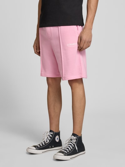 Männermodel trägt Sweatshorts mit Logo Modell 'KANE' von Jack & Jones in Rosa, Baumwoll-Mix, Relaxed-Fit, Nahaufnahme Oberschenkel.