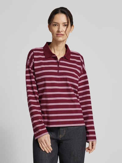 Modelka prezentuje Regular Fit Poloshirt aus Baumwoll-Mix von Tom Tailor Denim, efekt: wzór w paski, pika, mieszanka bawełny, krój regular fit, długi rękaw, kołnierzyk polo, listwa guzikowa, boczne rozcięcia, całkowity przód