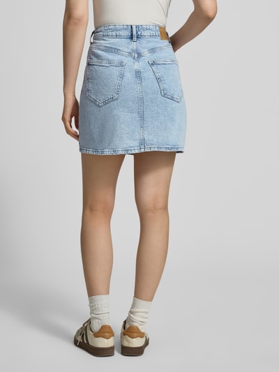 Frauenmodel trägt Regular Fit Jeansrock aus Baumwoll-Mix Modell 'TESSA' von Vero Moda in Denim-Optik, Mini-Länge, Label-Patch, Rückansicht.