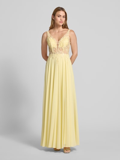 Frauenmodel trägt Abendkleid mit floralem Spitzenbesatz von Mascara, Tailliert, Paillettenbesatz, Semitransparent, V-Ausschnitt, Ganzkörperansicht von vorne.