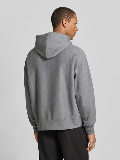 Mannelijk model draagt Hoodie mit Label-Print und Känguru-Tasche van CK Calvin Klein, mix van katoen en elastaan, relaxed fit, ruglengte 69 cm, mouwlengte 60 cm, grijs, rechte lijnen, zachte textuur. Ganzkörperansicht Rückansicht.