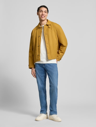 Männermodel trägt Slim Fit Jeans mit klassischem Five-Pocket-Design von REVIEW, Baumwoll-Elasthan-Mix, Blaue Waschung, Ganzkörperansicht von vorne.