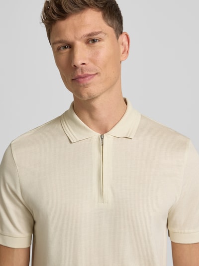 Męski model nosi Regular Fit Poloshirt aus Baumwoll-Lyocell-Mix Modell 'H-PARAS 70' od BOSS, kremowy kolor, pikowana faktura, krótki rękaw, widok na górną część ciała z przodu.