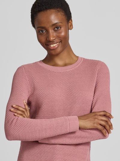 Frauenmodel trägt Strickpullover mit Strukturmuster und Rundhalsausschnitt von VILA in Rosa, reine Baumwolle, Slim Fit, Nahaufnahme Oberkörper.