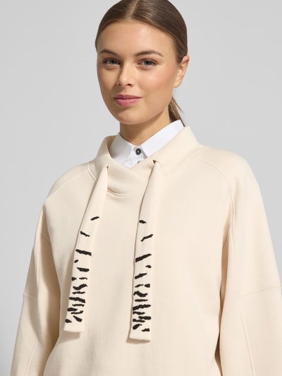 Kobiece modelka nosi Oversized Sweatshirt mit Tunnelzug von Marc Cain, mieszanka bawełny z dodatkiem streczu, stójka, tunel. Zbliżenie na górną część ciała.