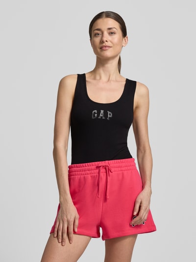 Frauenmodel trägt Slim Fit Top mit Logo-Print von GAP in Schwarz aus elastischem Baumwoll-Mix, Rundhalsausschnitt, Ganzkörperansicht von vorne. Rückenlänge bei Größe S: 58 cm.