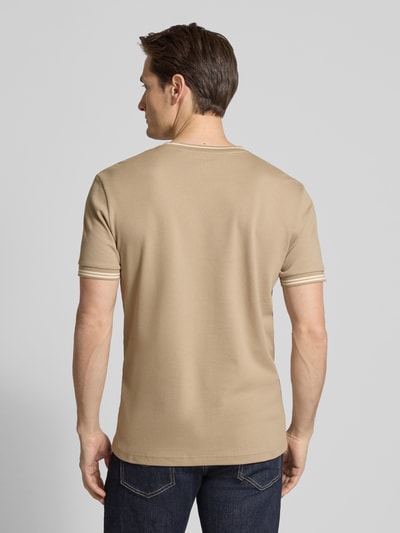 Męski model nosi T-shirt mit Strukturmuster und Rundhalsausschnitt od Christian Berg Men, mieszanka bawełny i elastanu, krój regular fit, fakturowany wzór, okrągły dekolt, długość tyłu w rozmiarze M: 70 cm, beżowy kolor, widok całej sylwetki z tyłu.
