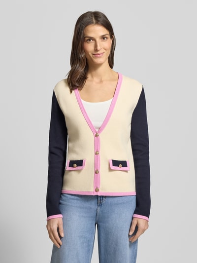 Kobiece modelka nosi Regular Fit Cardigan aus reiner Baumwolle von Christian Berg Woman w kolorach kremowym, czarnym i różowym, imitacja dzianiny, ozdobne guziki, dekolt w serek, długość tyłu 60 cm, długość rękawów 64 cm, widok całej sylwetki od przodu.