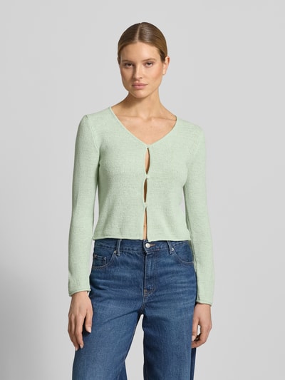 Frauenmodel trägt Strickjacke mit V-Ausschnitt von Tom Tailor Denim in Hellgrün, Regular Fit, Feinstrick, Knopfleiste, Ganzkörperansicht von vorne.