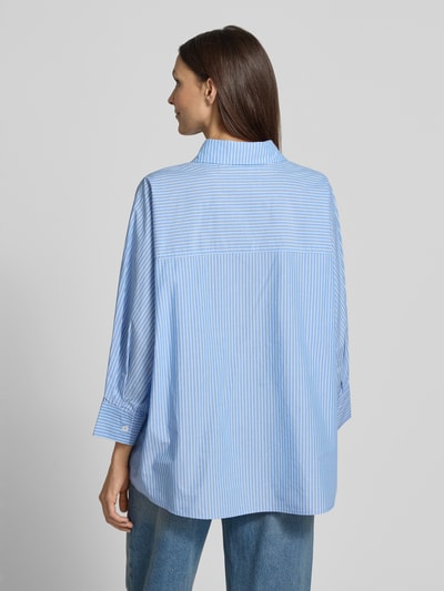 Frauenmodel trägt Relaxed Fit Hemdbluse aus reiner Baumwolle Modell 'Fionne' von OPUS PANTS, blau-weiß gestreift, Ganzkörperansicht Rückansicht.