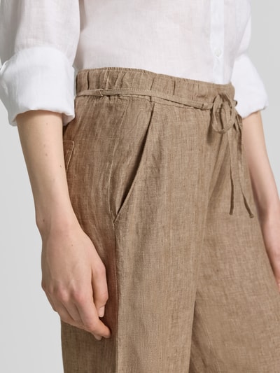 Kobiece model prezentuje Leinenhose mit Bindegürtel Modell 'Chiara' od MAC z lnu, szerokość w rozmiarze 36/32: 40 cm, długość wewnętrzna nogawki 84 cm, wpuszczane kieszenie, pas z wiązanym paskiem, krój wide leg fit, widok z przodu, zbliżenie na górną część.