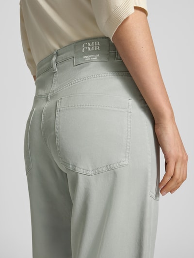 Kobieta nosi Relaxed Fit Jeans aus Lyocell-Mix od Cambio, model Occean, zielonoszare, gładka tekstura, wpuszczane i tylne kieszenie, mieszanka lyocellu i bawełny, szlufki z chustą, skrócony krój, szerokość w rozmiarze 36: 41 cm, długość wewnętrzna nogawki 69 cm, detal z tyłu, zbliżenie na pośladki.