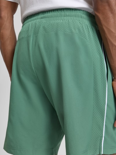 Männermodel trägt Shorts mit elastischem Bund und Logo von EA7 Emporio Armani, grün, Material-Mix, Regular Fit, Nahaufnahme Rückansicht.