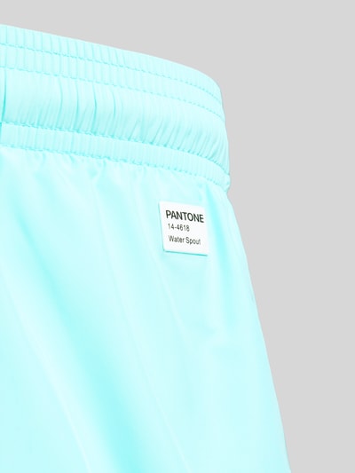 Produktfoto, hellblaue Badehose mit Logo-Print Modell 'Lighting Pantone' von MC2 Saint Barth, glatte Textur, Nahaufnahme Oberkörper, Geschenkebox.