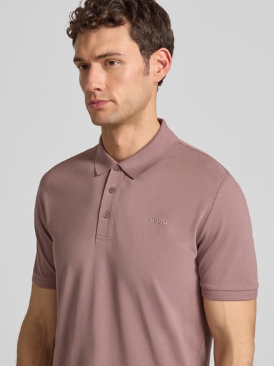 Männermodel draagt Regular Fit Poloshirt uit pure katoen model 'DONOS222' van HUGO, uni, piqué, labelprint, Nahaufnahme Oberkörper.