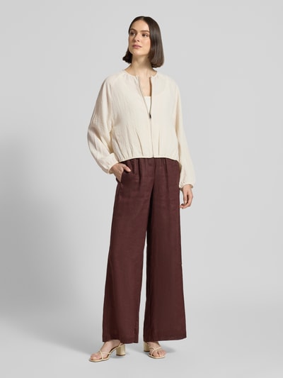 Frauenmodel trägt Blouson aus Viskose-Mix mit Rundhalsausschnitt Modell 'Jarosa' von OPUS, Loose-Fit, Reißverschluss, Raglanärmel, elastische Ärmelabschlüsse, helle strukturierte Textur, kombiniert mit weiter Hose, Ganzkörperansicht von vorne. Rückenlänge 50 cm, Schulterbreite 47 cm, Brustweite 54 cm, Ärmellänge 60 cm bei Größe 36.