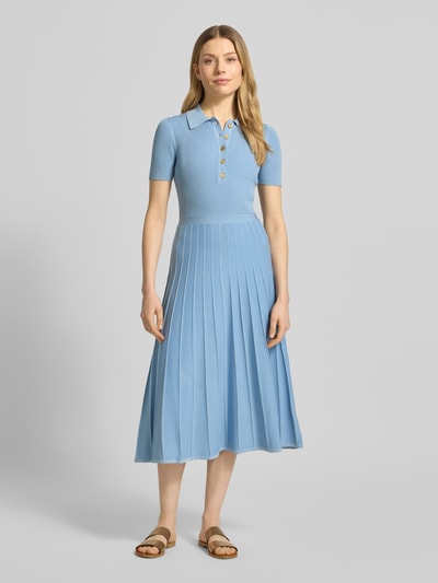 Frauenmodel trägt Midikleid aus Viskose mit Polokragen und Knopfleiste von MICHAEL Michael Kors in Hellblau, A-Linie, Ganzkörperansicht von vorne.