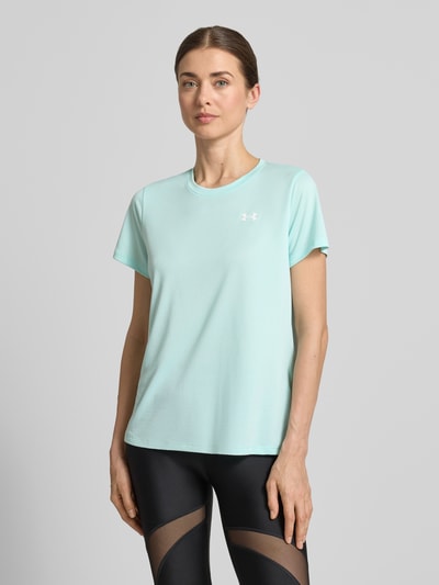 Vrouwenmodel draagt Funktionsshirt met ronde hals en logo van Under Armour, regular fit, ruglengte maat S 61 cm, mintkleur, vooraanzicht bovenlichaam.