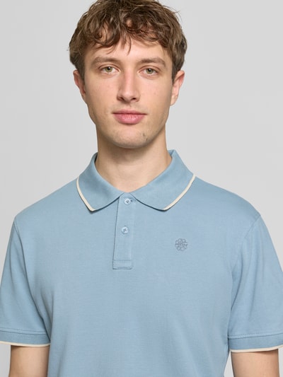 Männermodel trägt Regular Fit Poloshirt mit Logo-Stitching Modell 'Hedin' von Blend, reine Baumwolle, hellblau, Nahaufnahme Oberkörper.