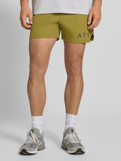 Männermodel trägt Shorts mit elastischem Bund von HALO in Olivgrün, Regular Fit, Label-Print, Material-Mix, Nahaufnahme Oberschenkel.