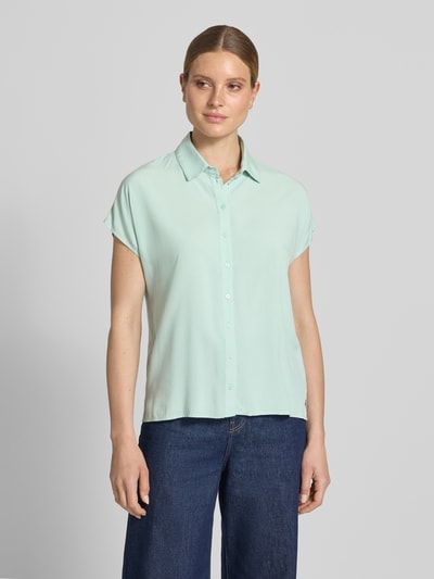 Frauenmodel trägt Relaxed Fit Bluse aus Reine Viskose von Christian Berg Woman in Hellgrün mit Hemdblusenkragen, Knopfleiste und Kappärmel, Ganzkörperansicht von vorne.