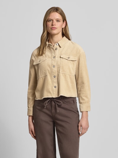 Frauenmodel trägt Boxy Fit Cordjacke aus reiner Baumwolle Modell 'MARINA-ENY LIFE' von Only, beige, unifarben, Fransen, Brusttaschen, Nahaufnahme Oberkörper.