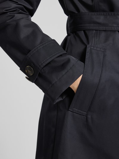 Frauenmodel trägt Regular Fit Mantel mit Umlegekragen von Fuchs Schmitt aus glattem, dunkelblauem Baumwoll-Mix, Detailaufnahme Tasche.