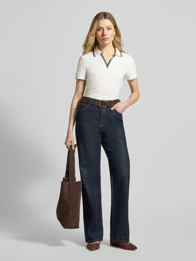 Modelka nosi Regular Fit Poloshirt mit V-Ausschnitt und Kontraststreifen von Jake*s Collection z bawełny, paski w kontrastowym kolorze, długość tyłu w rozmiarze S: 55 cm, widok całej sylwetki z przodu.