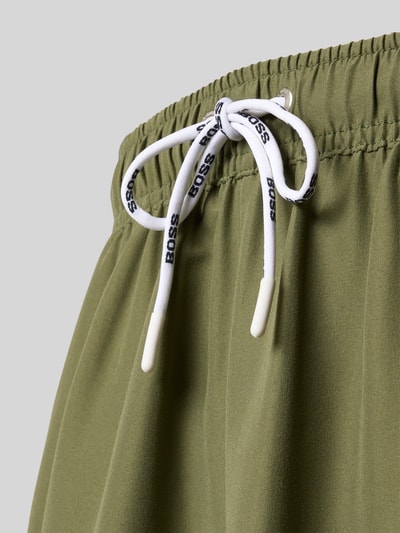 Produktfoto, Badeshorts mit Label-Applikation Modell 'DOGFISH' von BOSS, Optik: Unifarben, Passform: Regular-Fit, Tunnelzug, Bundabschluss: Elastisch, Gesäßtasche, seitliche Eingrifftaschen, glatte Textur, olivgrün mit weißem Tunnelzug.