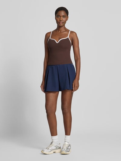 Frauenmodel trägt Trägertop mit Kontraststreifen Modell 'Sense Contour' von aim'n in Braun mit Weiß, körpernah, V-Ausschnitt, Ganzkörperansicht von vorne.