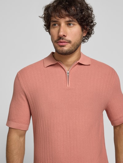 Männermodel trägt Regular Fit Poloshirt aus reiner Bio-Baumwolle Modell 'CRAN' von SELECTED HOMME in Strickoptik, Nahaufnahme Oberkörper.