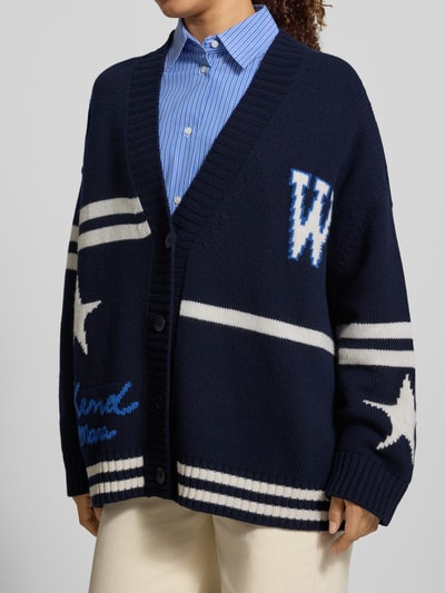 Frauenmodel trägt Oversized Strickjacke aus reiner Wolle Modell 'BELGIO' von Weekend Max Mara in Dunkelblau mit weißen und blauen Details, Damen Strickjacke von Weekend Max Mara, Nahaufnahme Oberkörper.