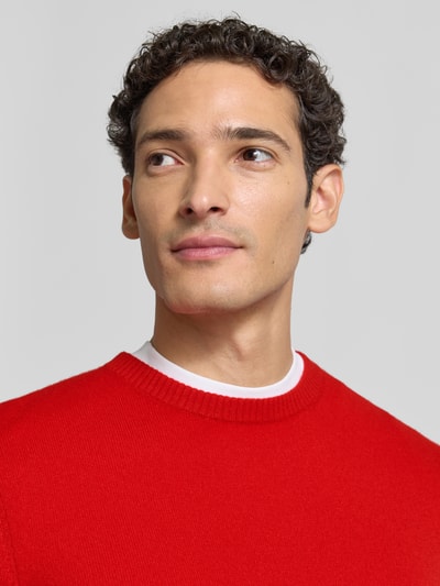 Männermodel trägt Kaschmirpullover mit gerippten Abschlüssen von Christian Berg Men in Rot, Rundhalsausschnitt, Nahaufnahme Oberkörper. Reines Kaschmir, gerader Schnitt.