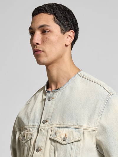 Männermodel trägt Jeansjacke mit Umlegekragen von MM6 Maison Margiela, Reine Baumwolle, Regular-Fit, Brust- und Eingrifftaschen, Nahaufnahme Oberkörper.