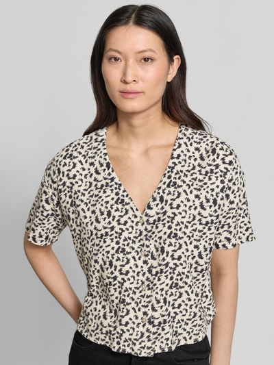 Kobiece model nosi bluzkę koszulową Boxy Fit Hemdbluse aus Viskose-Leinen-Mix model 'MYMILO' od Vero Moda w biało-czarny wzór, dekolt w serek, rękaw o dł. 3/4, wykończenie: cieniowana przędza, materiał: mieszanka wiskozy i lnu, z przodu, ujęcie: z przodu, górna część ciała