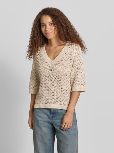Kobiece model prezentuje Boxy Fit Strickpullover aus Baumwoll-Mix Modell 'AMBER' von Pepe Jeans, beżowy, faktura dzianiny, aplikacja z metką, dekolt w serek, krótki rękaw, wykończenia prążkowane, mieszanka bawełny, imitacja dzianiny, ażurowy wzór, ganzkörperansicht von vorne.