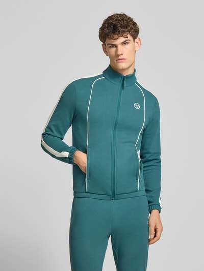 Männermodel trägt Slim Fit Tracksuit mit Logo-Stitching Modell 'Egeo' von SERGIO TACCHINI, petrolfarbener Baumwoll-Mix, Nahaufnahme Oberkörper.