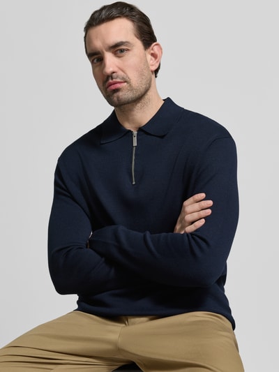 Männermodel trägt Relaxed Fit Pullover aus Viskose-Mix Modell 'TELLER' von SELECTED HOMME in Unifarben mit Polokragen, Feinstrick-Textur, Nahaufnahme Oberkörper.