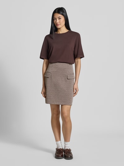 Kobiece modelka nosi spódnica mini z dodatkiem wiskozy Model 'Kate' od ICHI, elastyczna mieszanka materiałów, Linia a, Kieszenie z patką, fakturowany wzór, Szerokość w rozmiarze S: 38 cm, całkowita długość w rozmiarze S: 49 cm, widok całej sylwetki z przodu.