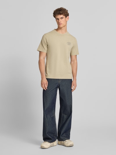 Männermodel trägt T-Shirt mit Label-Print Modell 'FELIX' von Jack & Jones Premium in Beige, Regular Fit, reine Baumwolle, Ganzkörperansicht von vorne.